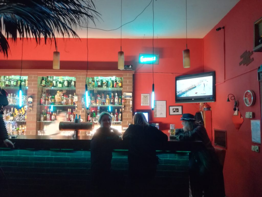 Group of friends in red bar with girl facing camera