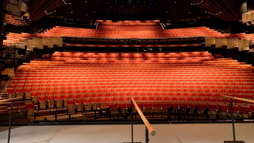 Become more confident when giving presentations: Stage of an opera house with red empty chairs in the audience