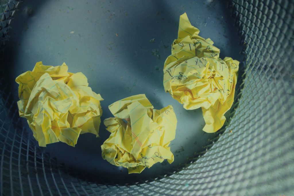 Crumbled up yellow paper in a waste basket