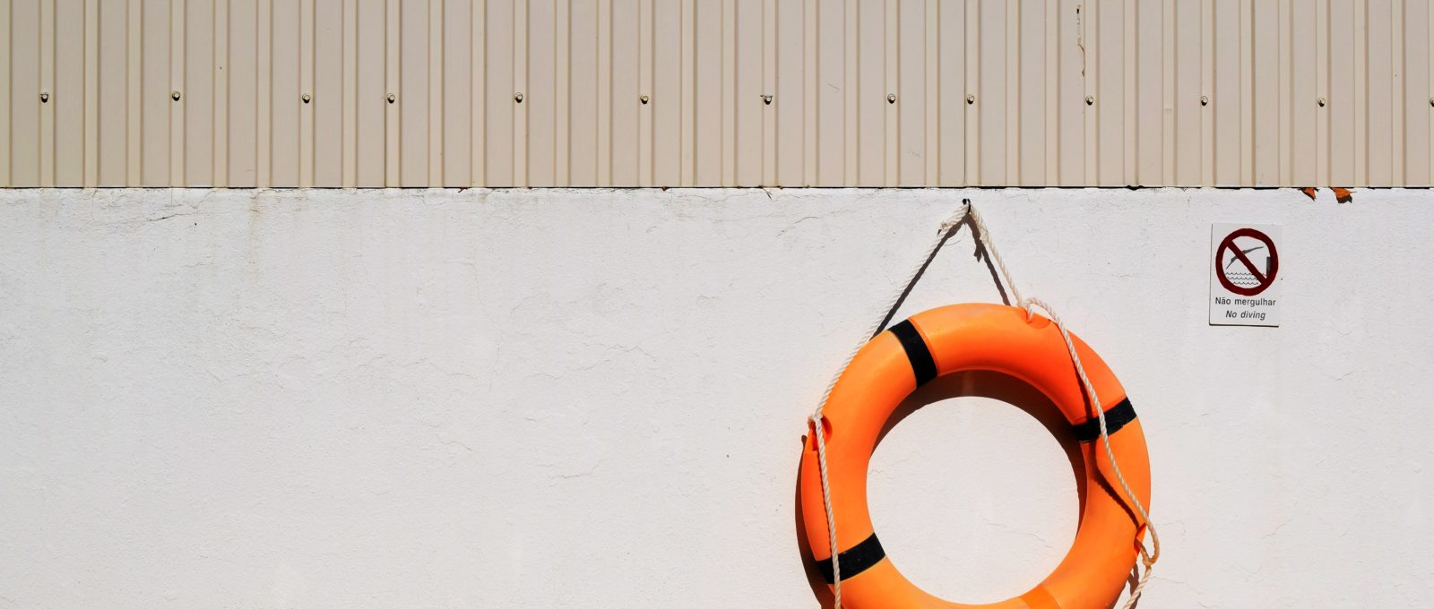 Orange Life Belt hanging from beige wall