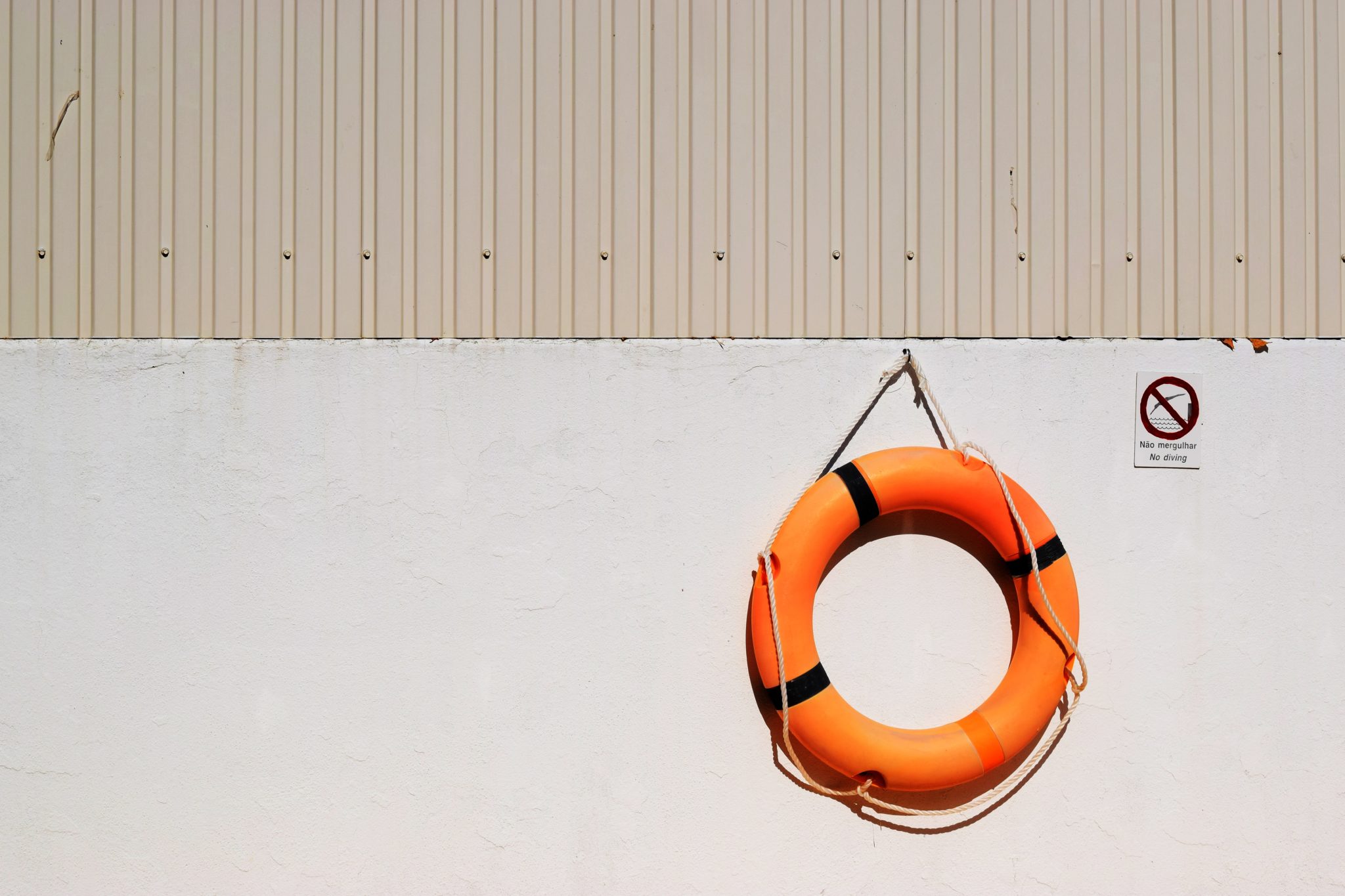Orange Life Belt hanging from beige wall