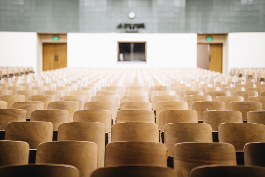 Empty lecture hall with wooden seats